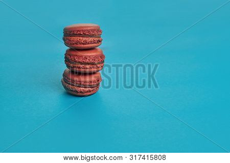 Colored Macaron Or Macaroon, Sweet Meringue-based Confection On Blue Background. Close-up, Copy Spac