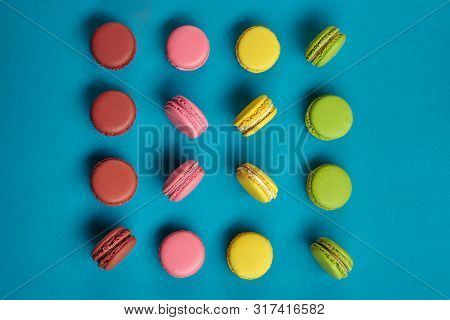 Colored Macaron Or Macaroon, Sweet Meringue-based Confection On Blue Background. Close-up, Copy Spac