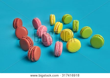 Colored Macaron Or Macaroon, Sweet Meringue-based Confection On Blue Background. Close-up, Copy Spac