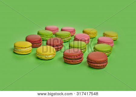 Colored Macaron Or Macaroon, Sweet Meringue-based Confection On Green Background. Close-up, Copy Spa