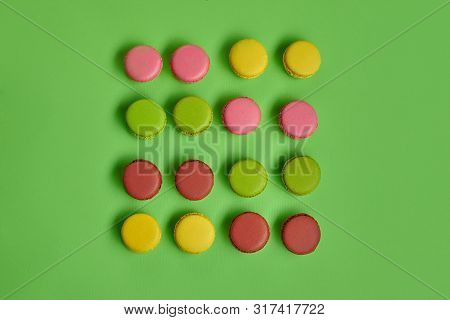 Colored Macaron Or Macaroon, Sweet Meringue-based Confection On Green Background. Close-up, Copy Spa