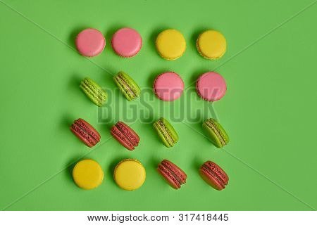 Colored Macaron Or Macaroon, Sweet Meringue-based Confection On Green Background. Close-up, Copy Spa