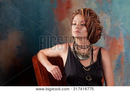 Southern Flavor. Stylish Beautiful Young Woman With Afro Braids Tucked Into A High Hair, Sitting In 