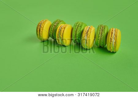 Colored Macaron Or Macaroon, Sweet Meringue-based Confection On Green Background. Close-up, Copy Spa