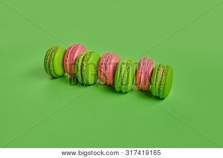 Colored Macaron Or Macaroon, Sweet Meringue-based Confection On Green Background. Close-up, Copy Spa