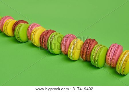 Colored Macaron Or Macaroon, Sweet Meringue-based Confection On Green Background. Close-up, Copy Spa
