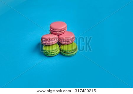 Colored Macaron Or Macaroon, Sweet Meringue-based Confection On Blue Background. Close-up, Copy Spac