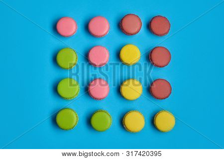 Colored Macaron Or Macaroon, Sweet Meringue-based Confection On Blue Background. Close-up, Copy Spac