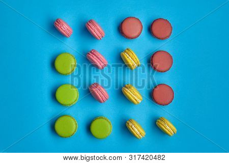 Colored Macaron Or Macaroon, Sweet Meringue-based Confection On Blue Background. Close-up, Copy Spac