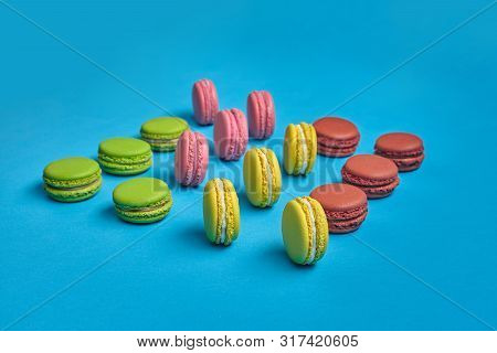 Colored Macaron Or Macaroon, Sweet Meringue-based Confection On Blue Background. Close-up, Copy Spac