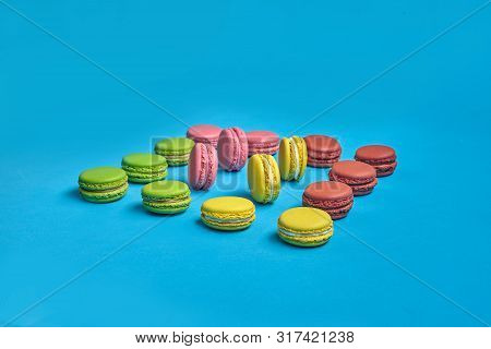 Colored Macaron Or Macaroon, Sweet Meringue-based Confection On Blue Background. Close-up, Copy Spac
