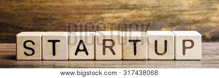 Wooden Blocks With The Word Startup. Temporary Structure Designed To Find And Implement A Scalable B