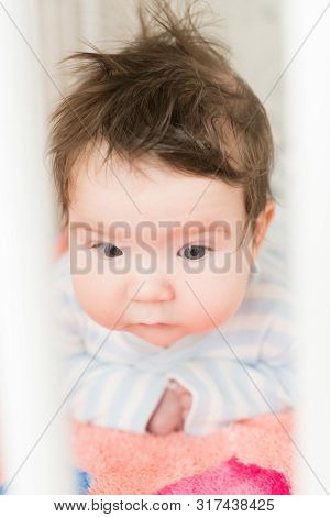 Baby In The Crib. Funny Baby In A White Canopy Bed. Childrens Room Interior And Bedding For Children