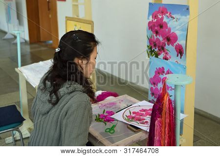 Pyongyang, North Korea - April 29, 2019: Girl Factory Worker With Needle And Silk Thread Over Canvas