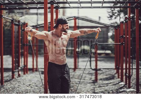 Fitness Man Exercising With Stretching Band. Muscular Sports Man Exercising With Elastic Rubber Band