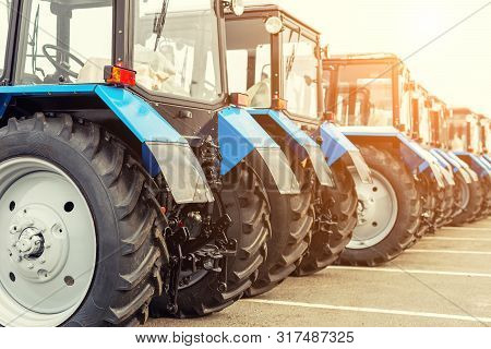 Many Different Tractors Standing In Row At Agricultural Fair For Sale Outdoors.equipment For Agricul