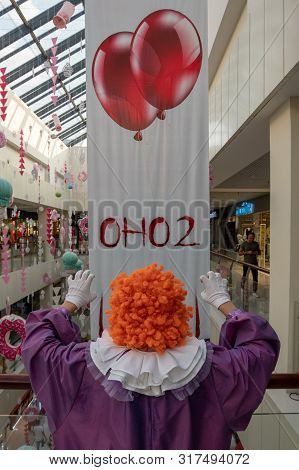 19-08-16. Kostanay, Kazakhstan. A Guy In A It Suit Is Standing In Front Of A Poster For A New Film. 