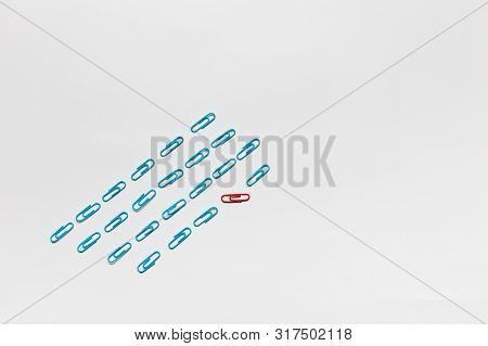 A Bunch Of Blue Paperclips Aligned And One Red Paperclip Nonaligned On White Background , Shot From