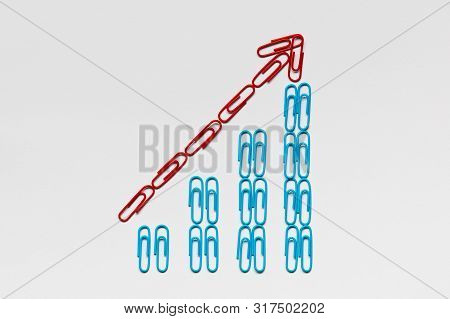 A Red Arrow Pointing Upwards Siting On A Stairwell Made From Blue Paperclips On White Background, Sh