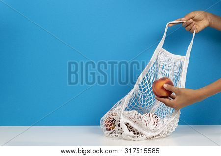 Top View To Kis Hands Putting Peaches In Mesh Glocery Shopping Bag