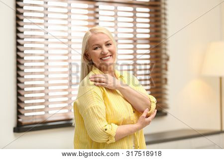 Portrait Of Happy Mature Woman Near Window Indoors
