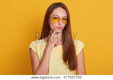 Close Up Portrait Of Beautiful Dark Haired Woman Points To Her Lips With Fore Finger, Has Virus, Bei
