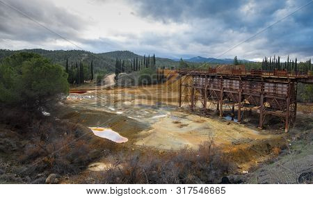 Abandoned Copper Mine With Red Toxic Water And Dramatic Stormy Cloudy Sky At Mitsero Area In Cyprus