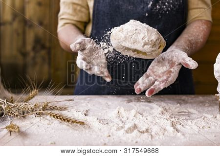 Womens Hands, Flour And Dough. Levitation In A Frame Of Dough And Flour. A Woman In An Apron Is Prep