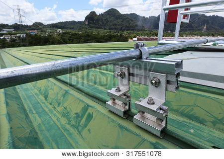 Electrical Conduit With Clamp Installation On Metal Sheet Roof. It Illustrates How Electrical Equipm