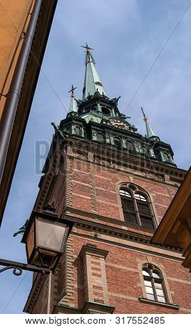 Sweden, Stockholm, On An Old Street In Gamlastan. The Ancient Part Of The City. The Bell Tower Of Th