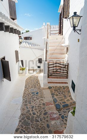 Narrow Street In The Traditional Fishing Village Of Binibeca On The Coast Of Menorca, Spain.