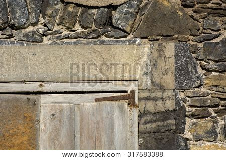 Photo Of A Old Building Facade With Door Detail, Wall And Sunlight.