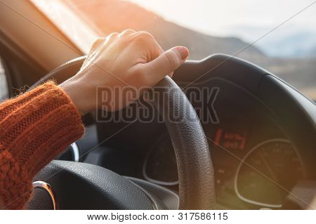 Close-up Of A Female Hand In An Orange Sweater Driving A Car Outside The City. Slow Motion Woman Dri