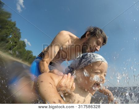 Father In Shorts Bathes His Son In Shorts In The Sea