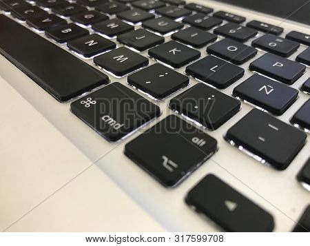 Black And White Keyboard With Illuminated Keys On Siver Portable Computer