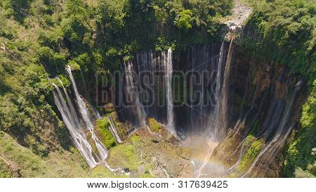 Aerial View Waterfall Coban Sewu In Java, Indonesia. Waterfall In Tropical Forest By Drone Tumpak Se