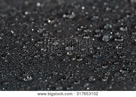 Dark Gray Waterproof Hydrophobic Flat Cloth Closeup With Rain Drops Selective Focus Background