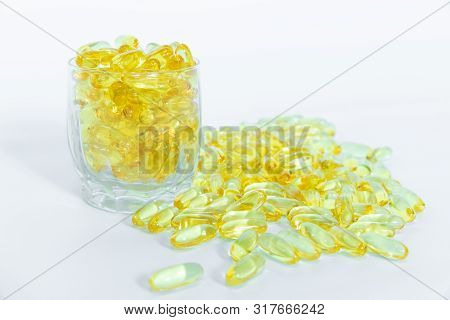 Omega 3-6-9 Fish Oil Yellow Softgels Into Glass Container And On White Background