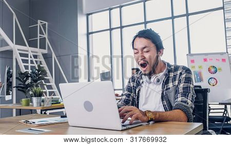 Creative Designer Yawn While Working Hard And Boring With Laptop At Modern Office.workplace Lifesyle