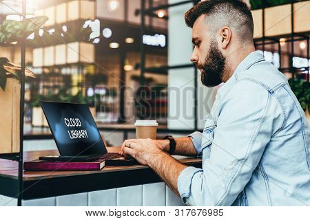 Bearded Hipster Man Sitting In Cafe And Typing On Laptop With Inscription On Monitor-cloud Library.