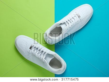 Fashionable White Sneakers On A Two-tone Background. Top View