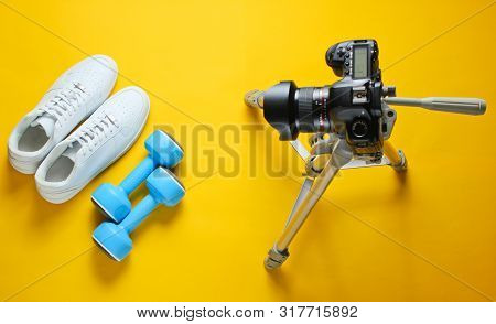 Minimalistic Sport Concept. Fitness Blogging. White Sneakers With Plastic Dumbbells And Camera With 