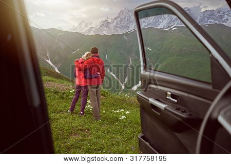 Happy Couple Hugs On Beautiful Nature And Mountains Out Of Car