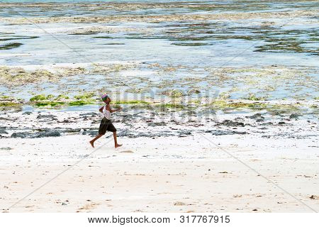 Stown Town, Tanzania - 11 January 2015: Local Boy Runs On Coast In Zanzibar