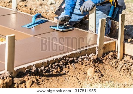 Construction Worker Using Hand Groover On Wet Cement Forming Coping Around New Pool.