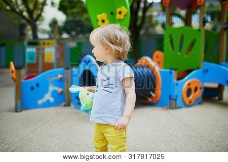 Adorable Toddler Girl Having Fun On Playground. Outdoor Activities For Kids