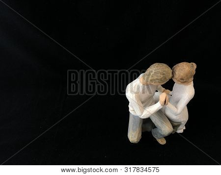 The Figure Of A Couple In Love. The Statuette He And She - Love. A Man And A Woman Are Sitting, Hugg