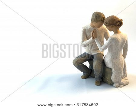 The Figure Of A Couple In Love. The Statuette He And She - Love. A Man And A Woman Are Sitting, Hugg