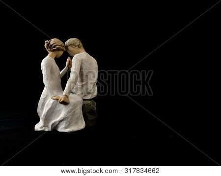 The Figure Of A Couple In Love. The Statuette He And She - Love. A Man And A Woman Are Sitting, Hugg