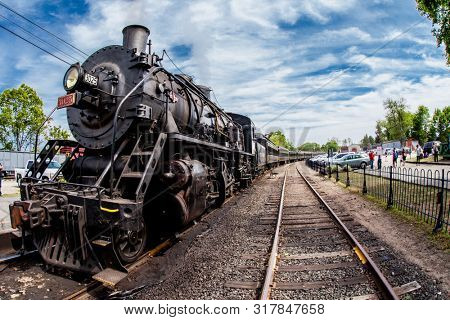 ESSEX, CT, USA - May 24, 2015: Connecticut Valley Railroad Steam Train Locomotive in train station with nice blue sky and clouds